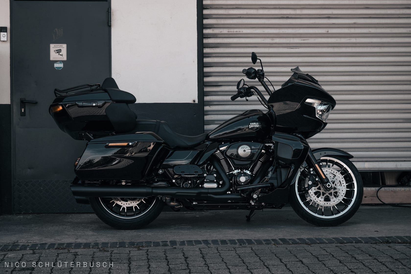 Schwarze Harley-Davidson Road Glide in der Seitenansicht vor einem Rolltor